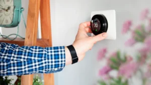 picture of homeowner adjusting wifi thermostat